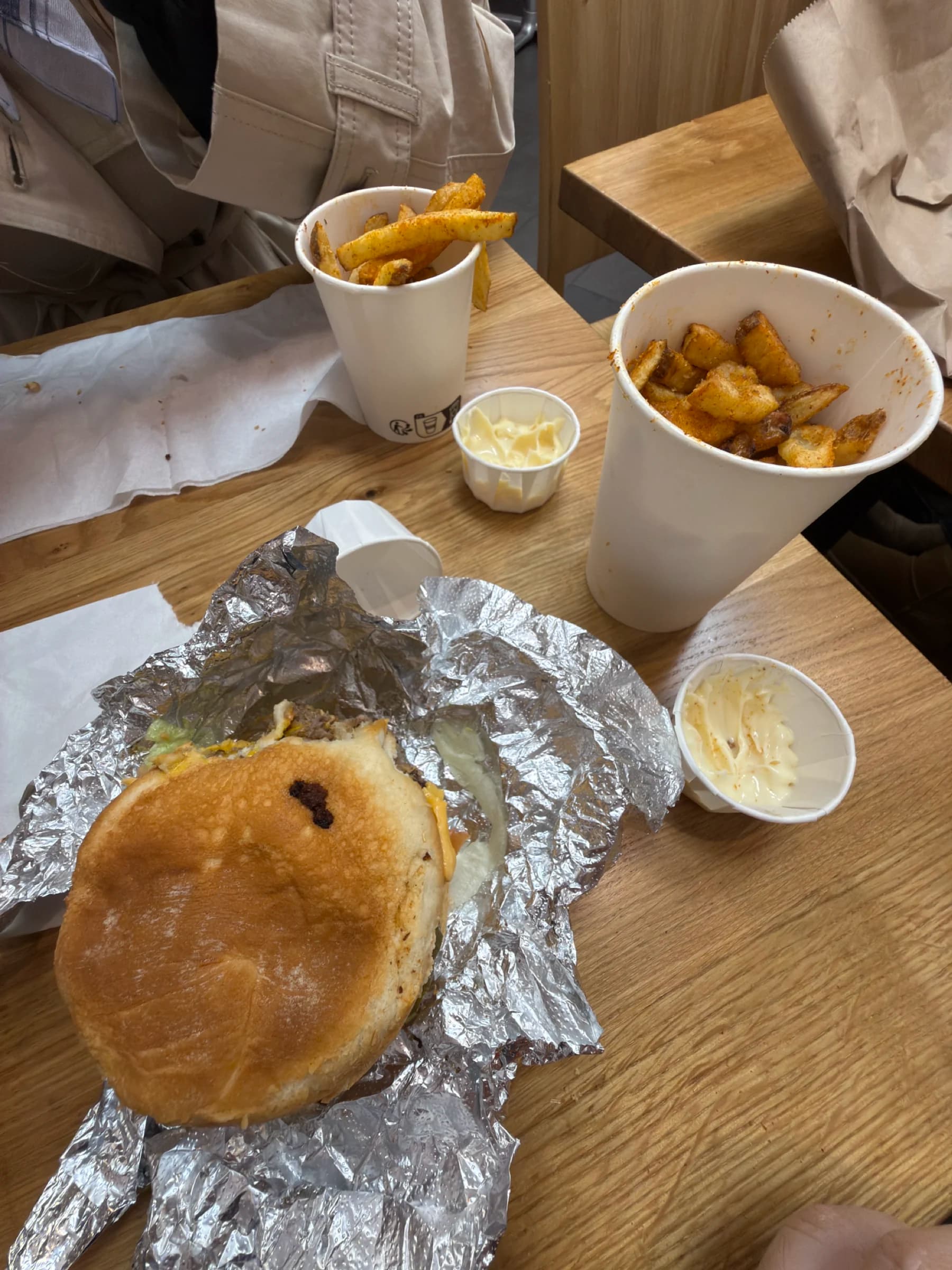Burger and seasoned potatoes on a wooden table